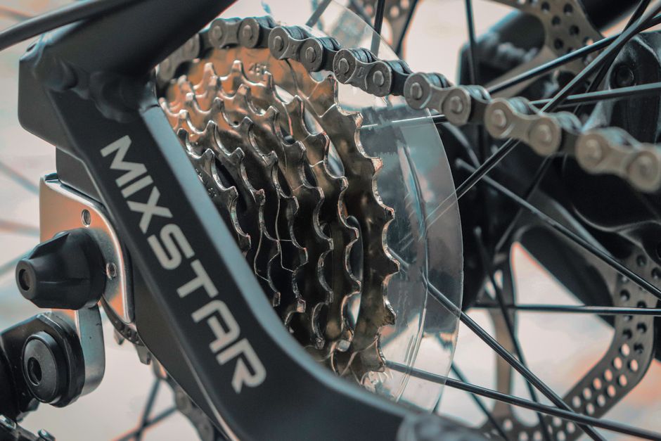 Detailed view of a bicycle chain and gear mechanism, highlighting engineering precision.